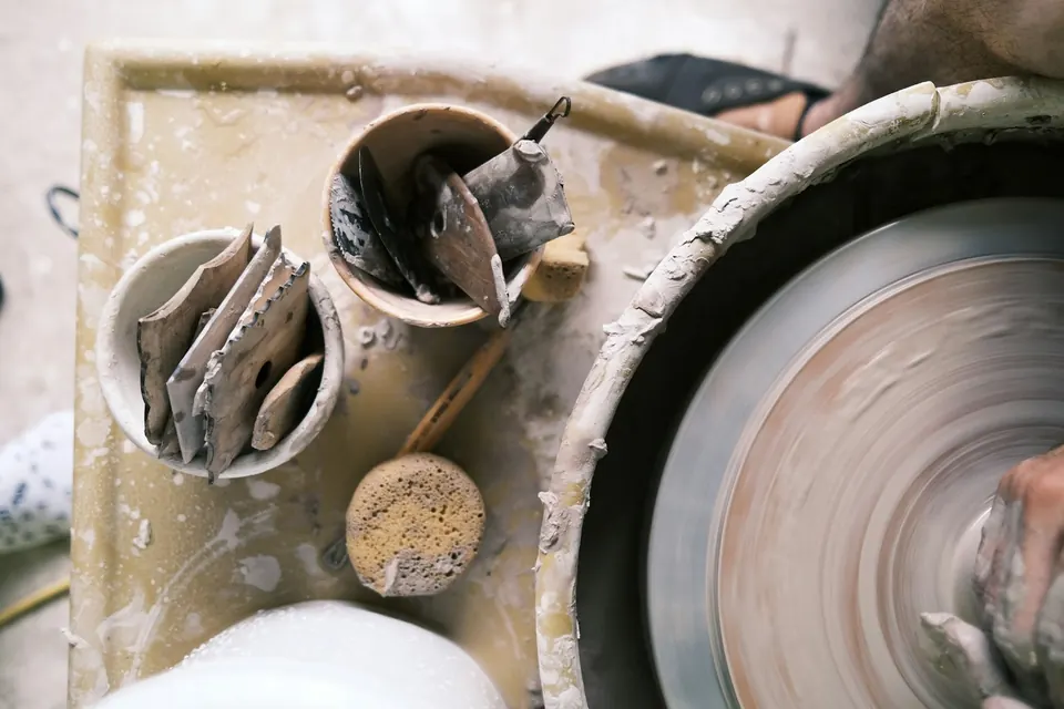 A spinning wheel and potter's tools in bowls
