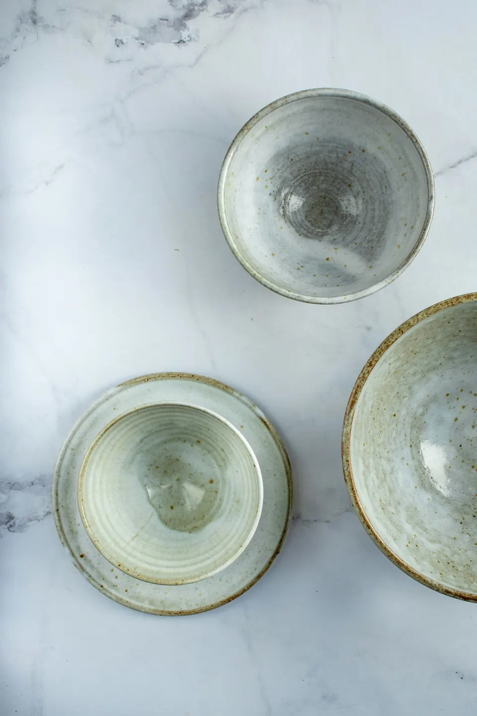 Three glazed stoneware bowls on marble